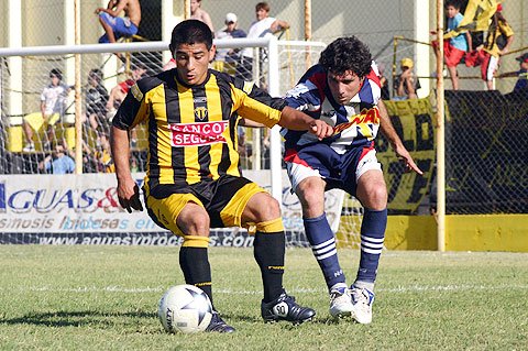 Cejas cubre la pelota ante el acoso del defensor entrerriano (Diego Rosso).