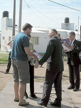 Carlos Feruglio, director de Vivienda, entregando el título de una vivienda.