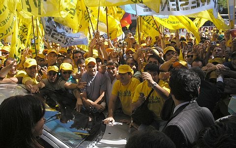 Cristina (abajo, izquierda) mira cómo su esposo se abalanza sobre el móvil policial (abajo, derecha) para saludar a la gente presente.