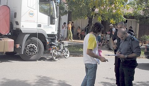 Los agentes toman los datos para el informe, detrás el camión y a la derecha los vecinos auxiliando a la mujer herida.