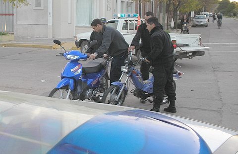 El momento en el cual, los policías levantan las motos para cargarlas en la camioneta de la Policía Municipal y despejar el lugar.