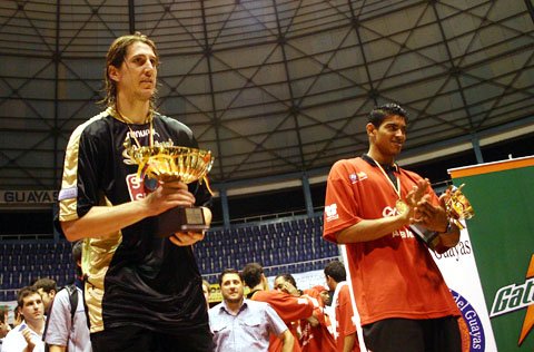 Pelussi posa con la copa del segundo puesto. A su lado un jugador de Joinville. Atrás esperan los de Biguá, campeones del torneo (Foto: Diego Rosso).