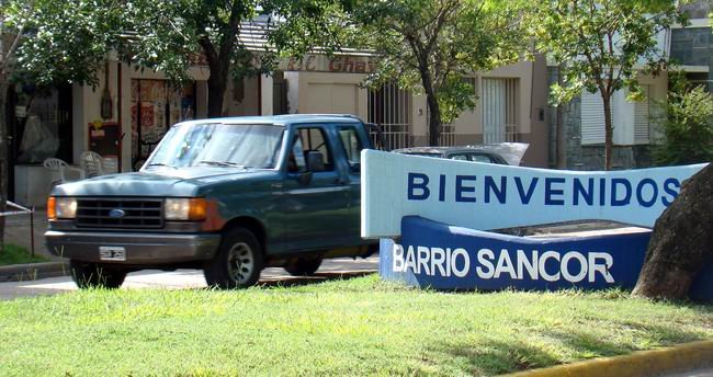 El cartel de acceso al barrio SanCor, sobre avenida Belgrano.