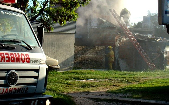 Los Bomberos, ingresando a la parte posterior de la vivienda siniestrada.