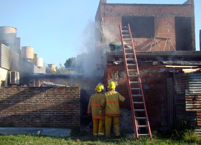 La construcción posterior, de dos pisos, con los Bomberos actuando.